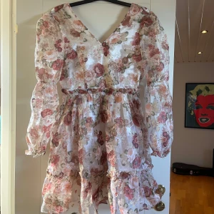 Blommig klänning - Fin blommig klänning, snörena bak har gått av men man kan antingen sätta fast nya eller ha klänningen med öppen rygg!