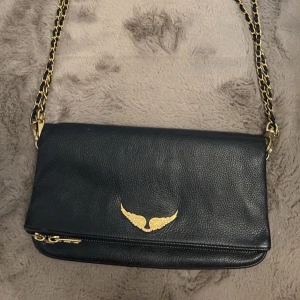 ZADIG & VOLTAIRE VÄSKA  - PRIS GÅR ATT DISKUTERAS! Zadig och Voltaire väska i svart och guld från Zalando, köpt för 3 595kr. Säljer pga  att jag inte längre använder den men fortfarande i fint skick och väldigt fin! 💕fråga om fler bilder 