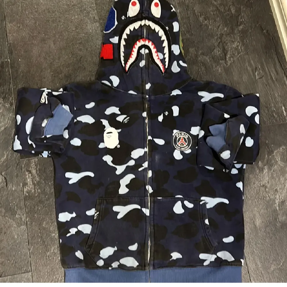 Säljer min snygga Bape hoodie som inte längre används. Den är i fint skick 8/10, storlek M men passar också S. Hör av er vid frågor och funderingar😉👌🏼. Hoodies.