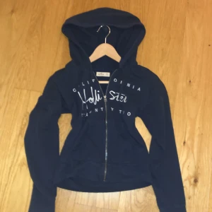 Hollister hoodie  - En snygg hoodie ifrån Hollister! Jag köpte den second hand, men   har itne använt den. Den e mörk blå med vit broderad text. Storlek xs, passar på mig som är 172 :)