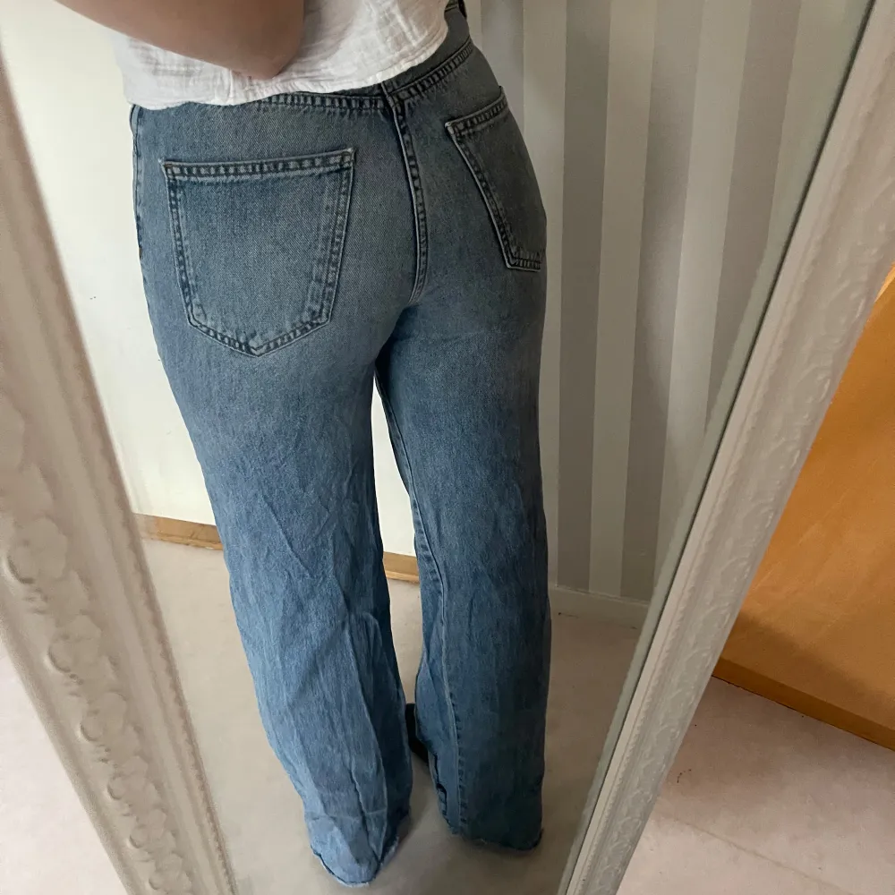 Säljer ett par klassiska blå jeans från Stradivarius. De har en straight passform och är tillverkade i jeansmaterial. Perfekta för en avslappnad stil och kan matchas med nästan vad som helst. De har en traditionell femficksdesign och en knappgylf.. Jeans & Byxor.