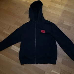 Hugo boss zip hoodie  - Säljer nu en svart Hugo boss zip hoodie, den e stilren och passar till mycket. Den har används vid få tillfällen och är i bra skick. Hör av dig vid intresse!