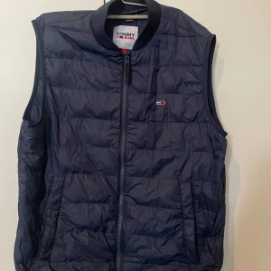 Tommy jeans väst S/M - Väl använt den har en sprickan som är lagat som ni ser på tredje bilden. Den är storlek s men passar ochså som en m