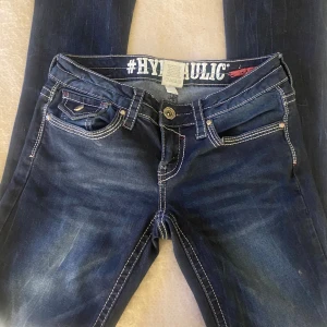 Lågmidjade jeans - Lågmidjade jeans med fina detaljer på fickorna De är bootcut/straight Midja rakt över ca 32-33 cm Innerbensmått 77cm  