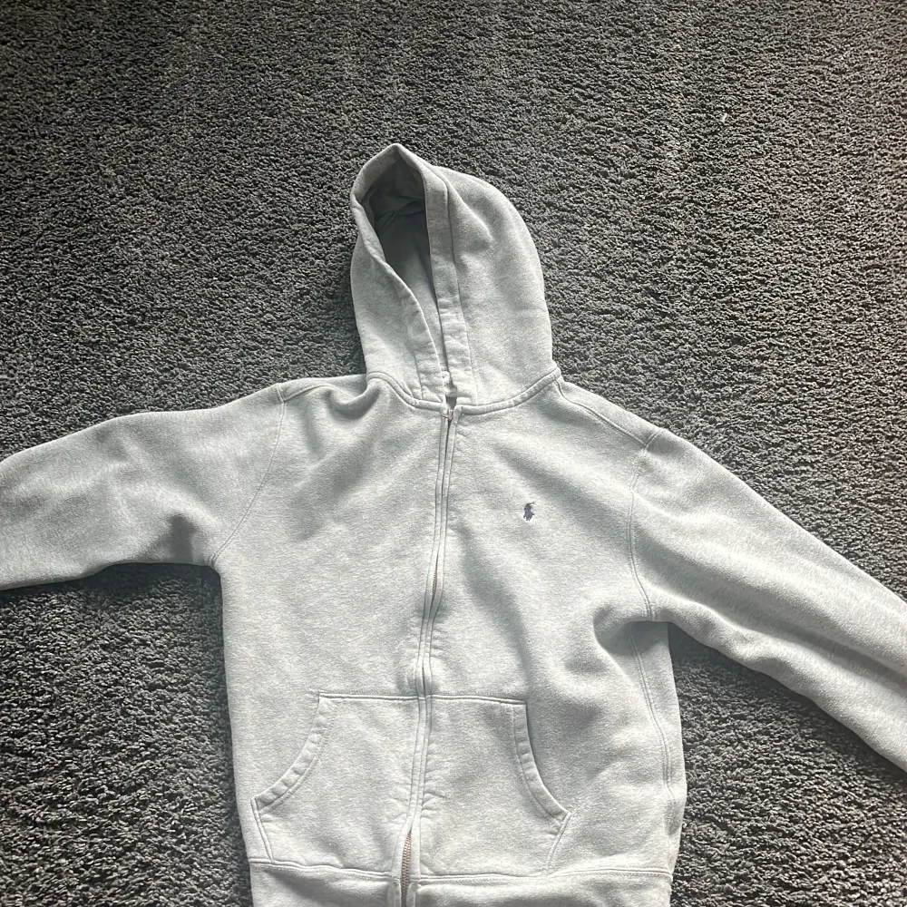 Det här är en grå Ralph lauren zip med luva. Den är storlek xl i barnstolek så alltså 14-16 år. Jag säljer den för att jag har växt ur den. Nypris 1100 kr. Hoodies.