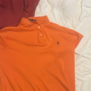 Ralph lauren piké  - Hej jag vill nu sälja min orangea Ralph lauren piké för att jag inte använder den och den är för stor för mig nu. Den är ej ÄKTA men den är fortfarande väldigt fin! Pris ej hugget i sten kom med bud!!