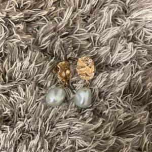 Guldörhängen med pärlor -  örhängen i guld med hängande pärlor.