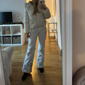Vita skidbyxor från Salomon - Fina vita skidbyxor från Salomon i storlek XS/34. Byxorna sitter fint och figurnära och är lite utsvängda nedtill. Man kan reglera midjan då det är kardborrband där. Mycket fint skick ✨