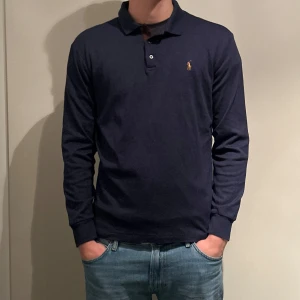Mörkblå pikétröja från Polo Ralph Lauren - Säljer en stilren mörkblå pikétröja från Polo Ralph Lauren. Endast testad så som ny, julklapp…Den är i en slim fit passform och tillverkad i mjuk bomull. Perfekt för en snygg och avslappnad look.