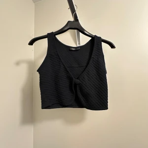 Svart ribbad linnetopp  - Snygg svart ribbad linnetopp från Lindex i storlek S. Den har  en knapp framtill. Jättesnygg på! Oanvänd! 