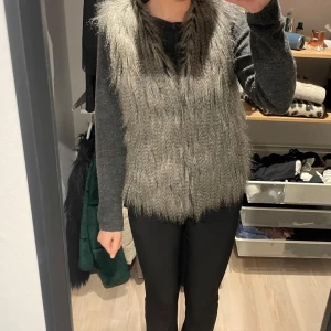 Grå pälsväst - Säljer denna snygga grå pälsväst i mycket bra skick. Perfekt för höst och vinter!