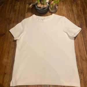 Vit stickad t-shirt från Bershka - Säljer en stilren vit t-shirt från Bershka i storlek S. T-shirten är kortärmad och tillverkad i ett mjukt material som ger en skön passform. Perfekt för en enkel och avslappnad look.