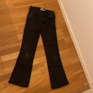 Svarta bootcut jeans från 157 - Snygga svarta bootcut jeans från Lager 157 med klassisk femficksdesign och knappdetaljer på bakfickorna. Perfekta för en retro look med 90-talsvibbar. Passar bra till både sneakers och boots  I storlek 150  (barn)