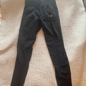 Svarta tights från ICANIWILL - Snygga svarta tights från ICANIWILL med hög midja. Perfekta för träning med en tight passform som ger bra stöd. Diskret logga på ena benet.