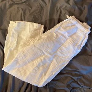 Vita linnebyxor från Kappahl - Snygga och bekväma vita linnebyxor från Kappahl. Perfekta för varma dagar med sin lätta och luftiga känsla. Byxorna har en elastisk midja med snörning för extra komfort.