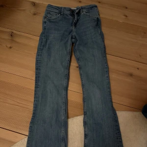 Blå jeansbyxor - Snygga blå jeansbyxor med klassisk design. De har en rak passform och är perfekta för en avslappnad stil. Byxorna har fem fickor och en knappgylf.