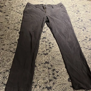 Svarta byxor från Max Martini - Snygga svarta byxor från Max Martini i storlek 50. Tillverkade av 97% bomull och 3% spandex för en bekväm passform. Byxorna har en klassisk design med dragkedja och knappar. Aldrig använda 