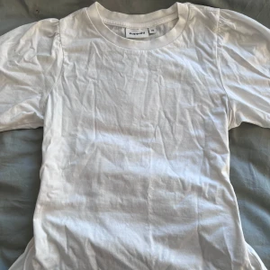 Vit t-shirt från Kappahl med lite puffärm 💞  - Säljer en klassisk vit t-shirt från Kappahl i storlek xs. T-shirten har korta ärmar och en rund halsringning. Perfekt basplagg för alla tillfällen. Lite puffärm HELT NY❤️