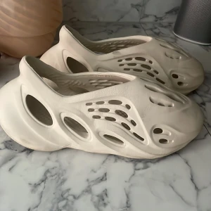 yeezy foam runners - Säljer ett par yeezy foam runners med futuristisk design och många utskärningar. Perfekta för en modern och stilren look.  Storlek 45 
