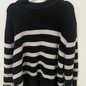 Svart och vit randig tröja från Gina Tricot - Säljer en snygg svart och vit randig tröja från Gina Tricot. Tröjan är stickad med långa ärmar, lite nopprig men annars i bra skick! Storlek M men sitter mer som en S