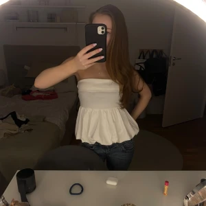 Vit tubtopp från Gina Tricot - Säljer en söt vit tubtopp från Gina Tricot. Toppen har en volangdetalj nedtill som ger en fin touch. Perfekt för varma sommardagar eller en kväll ute. Väldigt bra skick!💕☺️