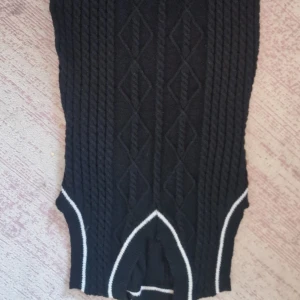 Svart stickad topp från Shein - Säljer en snygg svart stickad topp från Shein i storlek 1XL. Den har ett coolt flätmönster och vita detaljer vid nederkanten. Perfekt för höst och vinter, och den är supermjuk och bekväm. Passar både till vardags och fest!