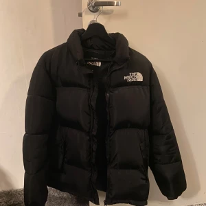 Svart pufferjacka från The North Face - Hej, jag säljer en svart pufferjacka från The North Face i storlek M. Jackan är i toppskick och perfekt för kalla dagar med sitt tjocka och varma material. Perfekt för vintern! ❄️