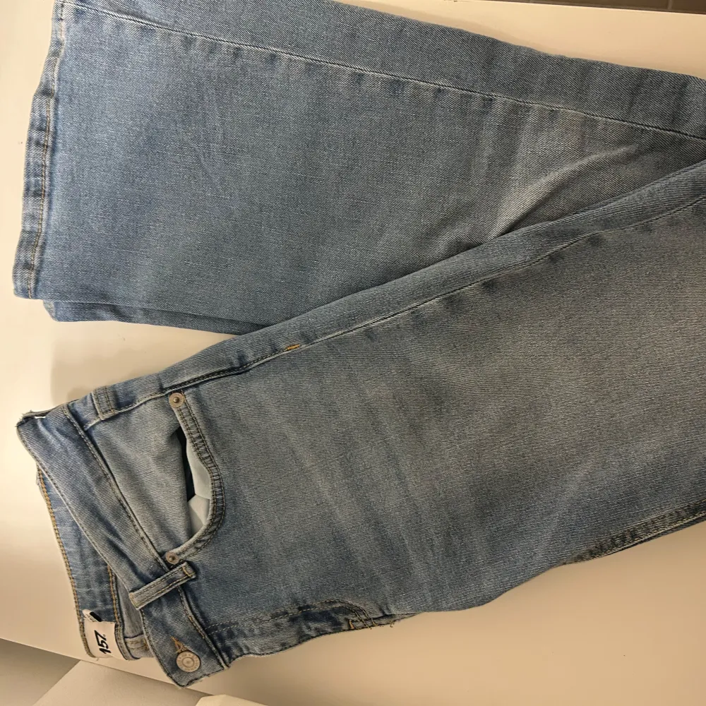 Säljer ett par snygga blå jeans i bootcut-stil. Jeansen är i bra skick och har en bekväm passform. Dom är låga i midjan och är i short modell så det är därför dom inte passar. Jag är 167 och dom va nån cm förkorta för min smak.🩵. Jeans & Byxor.