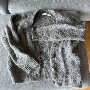 Grå stickad kofta - Säljer den här jättemysiga och varma grå koftan som jag knappt använt.