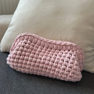 Rosa virkad väska - Säljer en superfin rosa virkad väska som är perfekt för att hålla ordning på småsaker. Den är handgjord med ett tjockt garn som ger en mysig och unik look. Perfekt som en liten handväska eller förvaring hemma. 🧶💖