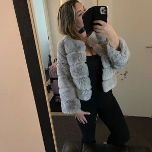 Grå pälsjacka - Säljer en supermjuk och fluffig grå fuskpälsjacka. Den är perfekt för att hålla sig varm och snygg under kyliga dagar. Jackan är croppad och har långa ärmar, vilket ger en trendig look. Passar perfekt till både vardag och fest! 🐾