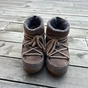 Inuikii skor - Säljer ett par mysiga bruna inuikii boots i  bra skick. De är fodrade med päls och har snörning framtill. Perfekta för kalla vinterdagar och håller fötterna varma och sköna. De har en robust sula som ger bra grepp på hala underlag. Storlek 37 men passar mig i 38. Så passar både 37-38. Har inte rengjort dem, så skulle sannolikt bli i mycket bättre skick efter lite kärlek 🤎