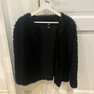 fluffig kofta - Säljer en supermysig svart fluffig kofta från H&M💕Perfekt för höst och vår, den har en långärmad design. Jackan har en loose passform och är i väldigt bra skick. Perfekt för både vardag och festliga tillfällen!