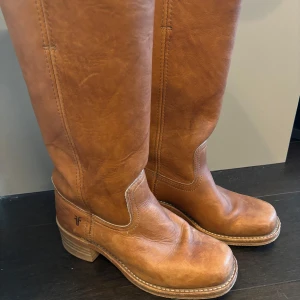 Frye boots - Säljer ett par snygga bruna läderstövlar från Frye i mycket bra skick. De är tillverkade i USA och har en klassisk design med rund tå och robust sula. Perfekta för höst och vinter