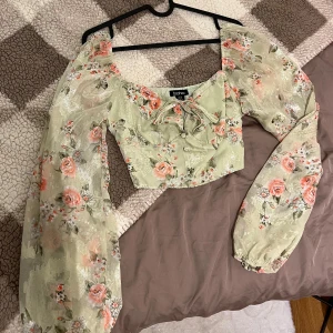 Boohoo blus - En söt och blus med puffärmar och ett blommigt mönster. Blusen har en spetsdetalj i mitten och en avslappnad passform. Bra skick!