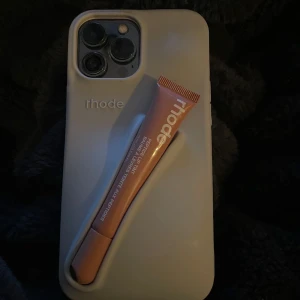 Rhode Peptide Lip Tint - Säljer en Rhodes skal med deras lip tint. Till iPhone 13 PRO Max   Aldrig använt läppglansen eller skalet då det var Alldeles för tjockt för min smak. Väldigt fint skal dock.   Köpte det för 56$, priset kan diskuteras   Säljer skalet och läppglansen tillsammans.   Läppglansen är i färgen toast