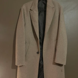 Beige kappa från zara  - Säljer en stilren beige kappa i mycket bra skick. Den har en klassisk design. Perfekt för höst och vår, och ger en elegant touch till vilken outfit som helst. Säljer den för 800 och nypris är 1500