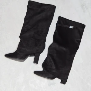 Boots  -  Svarta Boozt från prettylittlething storlek 38/5 Dem är använda 2 gånger så väldigt bra skick  Säljer då dem tyvärr inte kommit till användning så mycket som jag önskat 🩷 Köpta för £65 vilket är ca 845 SEK. Har köpt som ilägg att ha på dig för att ej lägga så mycket vikt på trampdynan om man går under längre tid som jag kan skicka med, oanvända. Klack 10 cm