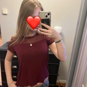 Vinröd topp med meshdetaljer - Snygg vinröd topp med korta ärmar och transparenta meshdetaljer vid halsen. Superfin till både vardaglig men även festlig användning💕💕