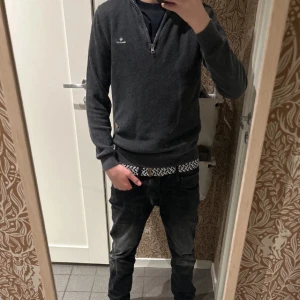 Grå tröja med dragkedja från GANT - Snygg grå tröja från GANT med dragkedja och diskret logga på bröstet. Perfekt för kyligare dagar med sin stilrena design och bekväma passform. Storlek S (Endast använd ett fåtal gånger då den är för liten)