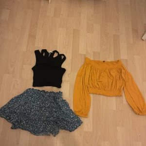 Svart ribbad topp och senapsgul offshoulder blus - Säljer en stilren svart ribbad topp med breda axelband och en senapsgul offshoulder blus med långa ärmar och elastisk midja. Perfekt för att mixa och matcha i garderoben! Säljer även en blommig kjol.