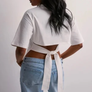 Nelly topp - Snygg vit croppad topp med korta ärmar och knytband i ryggen. Slutsåld på Nellys hemsida och endast använd en gång.