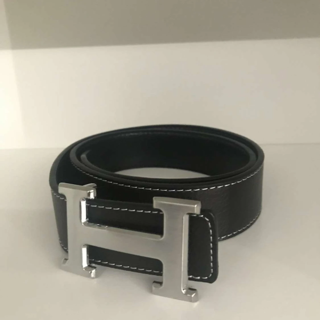 Svart skärp med silverfärgat H-spänne