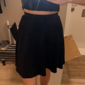 Svart kjol - Snygg svart kortkjol med en enkel och stilren design. Perfekt för att matcha med olika toppar och accessoarer.