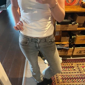Grå jeans med bootcut - Snygga grå jeans med bootcut-stil och mid waist. De har klassiska fem fickor och en knappgylf. Perfekta för en avslappnad look.