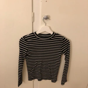 Randig långärmad tröja från Lindex - Säljer en randig långärmad tröja från Lindex i svart och vit. Perfekt för en stilren look med klassiska ränder. Tröjan är i barnstorlek 146/152 och passar åldrarna 10-12 år.