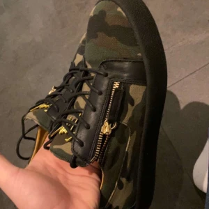 guiseppe Camouflage sneakers  - Snygga sneakers i camouflage-mönster med svarta detaljer och dragkedja på sidan. Skorna har en robust sula och snörning framtill. Perfekta för en avslappnad stil. Säljs för super bra pris 1300kr riktig steal