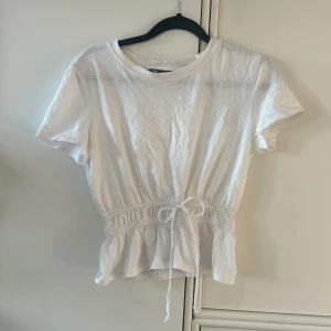 T-shirt med resår i midjan - Säljer denna supersöta t-shirten från Zara som inte går att få tag på längre! Resår i midjan, snöret går inte att dra åt - bara prydnad!
