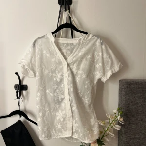 Vit söt blus med blommor! - Använd fåtal gånger, kan användas åt båda hållen. 