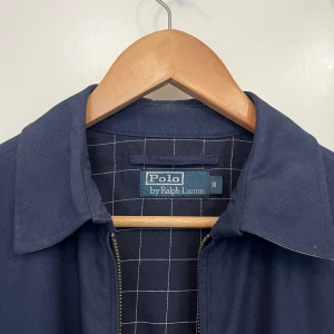 Ralph Lauren jacka  - Ralph lauren-jacka. Använd 1 gång. Nypris 2395kr. Mörkblå i färgen. Storlek S för herrar och kanske S/M för damer. 